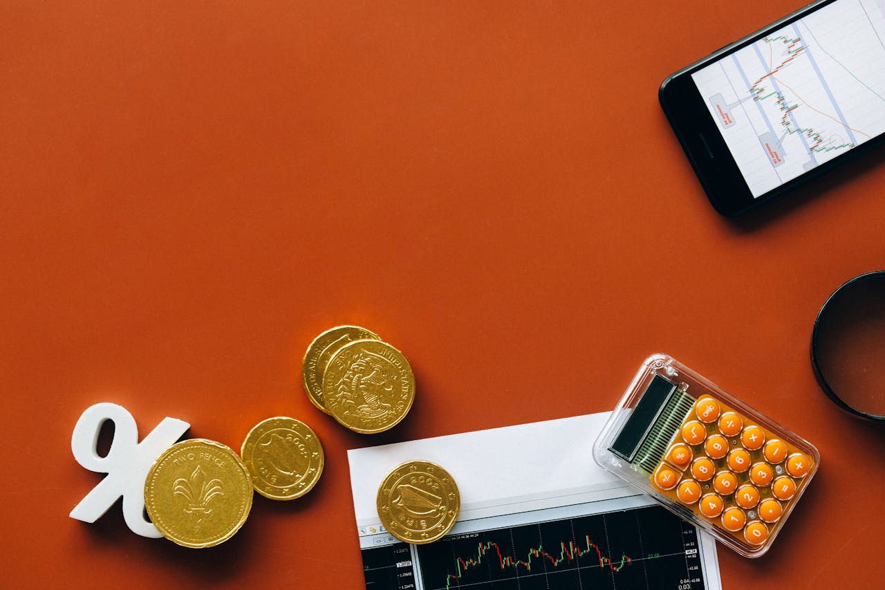 services-03 Flat lay showing coins, calculator, and charts on a red background for financial analysis and business concepts.